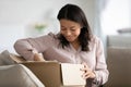 Happy biracial woman unpack cardboard box with online order Royalty Free Stock Photo