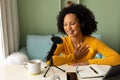 Happy biracial woman using headphones, tablet and microphone podcasting from home Royalty Free Stock Photo