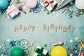 Happy birthday banner. Colorful holiday supplies on blue vintage table top view. Flat lay style. Royalty Free Stock Photo