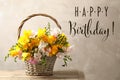 Happy Birthday! Beautiful freesia flowers in wicker basket on table