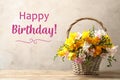 Happy Birthday! Beautiful flowers in wicker basket on table