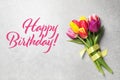 Happy Birthday! Beautiful spring tulips on grey stone table, top view Royalty Free Stock Photo