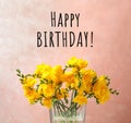 Happy Birthday! Beautiful yellow freesia flowers in glass vase against pink background Royalty Free Stock Photo