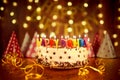 Happy birthday cake with candles on the background of garlands a Royalty Free Stock Photo