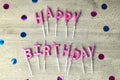 Happy birthday candles and glitter on gray wooden background Royalty Free Stock Photo
