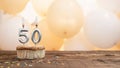 Happy birthday card with candle number 50 in a cupcake against the background of balloons. Copy space happy birthday for fifty Royalty Free Stock Photo