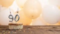 Happy birthday card with candle number 90 in a cupcake against the background of balloons. Copy space happy birthday for ninety