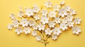 Flat lay greeting card with beautiful little white flowers on bright yellow paper background Royalty Free Stock Photo