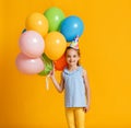 Happy Birthday! child girl with balloons on yellow background