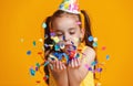 Happy birthday child girl with confetti on yellow background