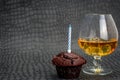 Happy birthday Chocolate maffin on gray background with candle and glass cognac and English money