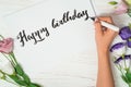 Happy birthday congratulations. Calligrapher writes with black ink on white card. Calligraphy. Ornament font. The art of