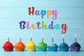 Happy Birthday! Delicious cupcakes with burning candles on blue wooden table Royalty Free Stock Photo