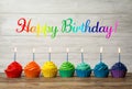 Happy Birthday! Delicious cupcakes with burning candles on wooden table Royalty Free Stock Photo