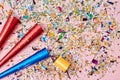 Happy birthday. Festive party. Event decoration. Bright colourful confetti. Red and blue firecrackers on pink backdrop
