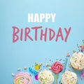 Happy Birthday! Flat lay composition with cupcakes on light blue background Royalty Free Stock Photo