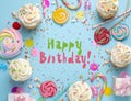 Happy Birthday! Flat lay composition with cupcakes on light blue background Royalty Free Stock Photo
