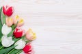 Happy birthday frame border, bouquet of tulips on a white wooden background, floral greeting card, colorful festive template with Royalty Free Stock Photo