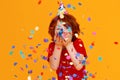 Happy birthday! ginger child boy with confetti on yellow background Royalty Free Stock Photo