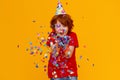 Happy birthday! ginger child boy with confetti on yellow background Royalty Free Stock Photo