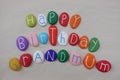 Happy Birthday Grandmum with colored stones over white sand