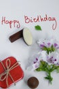 Happy birthday greeting card with gift box, fresh flowers and chocolates