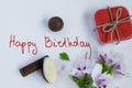 Happy birthday greeting card with gift box, fresh flowers and chocolates