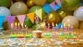 Happy birthday greeting card to 1 year old child, birthday cupcake with burning candles and birthday decorations on blue backgrou