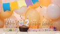 Happy birthday greetings for 82 years from gold letters of candles burning against the background of mine space balloons. Royalty Free Stock Photo