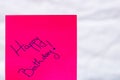 Happy birthday handwriting text close up isolated on pink paper with copy space. Writing text on memo post reminder Royalty Free Stock Photo