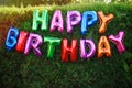 Happy Birthday! The inscription of colorful balloons, decoration at a festive garden party on the background of a green hedge Royalty Free Stock Photo