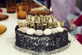 Happy birthday lit candles on chocolate cake Royalty Free Stock Photo