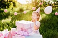 Happy birthday little girl with pink decor in beautiful garden Royalty Free Stock Photo
