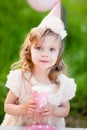 Happy birthday little girl with pink decor in beautiful garden Royalty Free Stock Photo