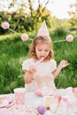 Happy birthday little girl with pink decor in beautiful garden Royalty Free Stock Photo