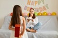 Happy birthday my mother. Child congratulating mom. Mum and daughter celebrating event together, little kid posing backwards Royalty Free Stock Photo