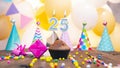 Happy birthday with a number of candles for twenty-five years on the background of balloons. A festive muffin with burning candles Royalty Free Stock Photo