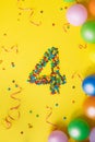 Happy Birthday number 4 made of candies with colorful balloons on yellow background Royalty Free Stock Photo