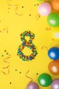 Happy Birthday number 8 made of candies with colorful balloons on yellow background Royalty Free Stock Photo