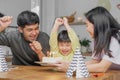 Happy birthday party in family, asian young parent father, mother and little cute boy or child celebrating, blowing candles on the Royalty Free Stock Photo