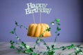 Happy birthday ring cake with clover decoration on marble table and lilac background Royalty Free Stock Photo