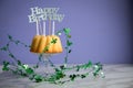 Happy birthday ring cake with clover decoration on marble table and lilac background Royalty Free Stock Photo