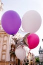 Happy birthday surprise. Bright balloons against beautiful antique building in European town. Valentines day, engagement idea Royalty Free Stock Photo