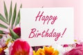 Happy birthday text on card in flower bouquet on pink background. Flower delivery, congratulation card. Greeting card in Tulips, Royalty Free Stock Photo