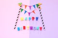 Happy Birthday text with colorful paper flags garland.