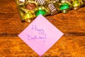 Happy birthday text on memo post reminder, near a golden box with chocolate pralines Royalty Free Stock Photo