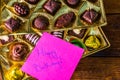 Happy birthday text on memo post reminder, near a golden box with chocolate pralines Royalty Free Stock Photo