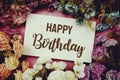 Happy Birthday typography text with flowers frame on pink background