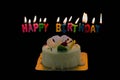Happy Birthday wording candles lighting above white cake with cl Royalty Free Stock Photo
