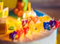 Happy birthday written in lit candles on colorful background Royalty Free Stock Photo